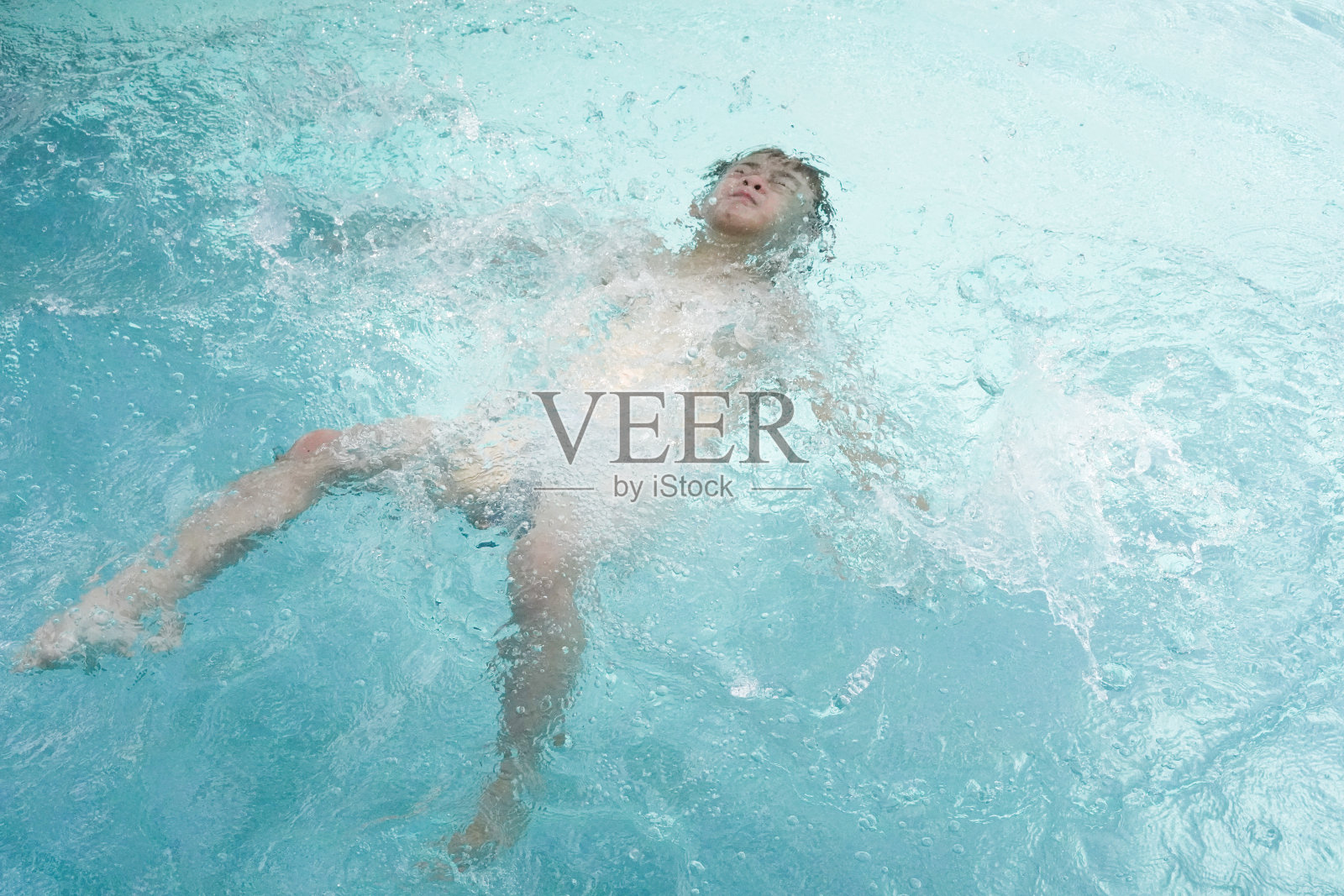 男孩在游泳池游泳照片摄影图片