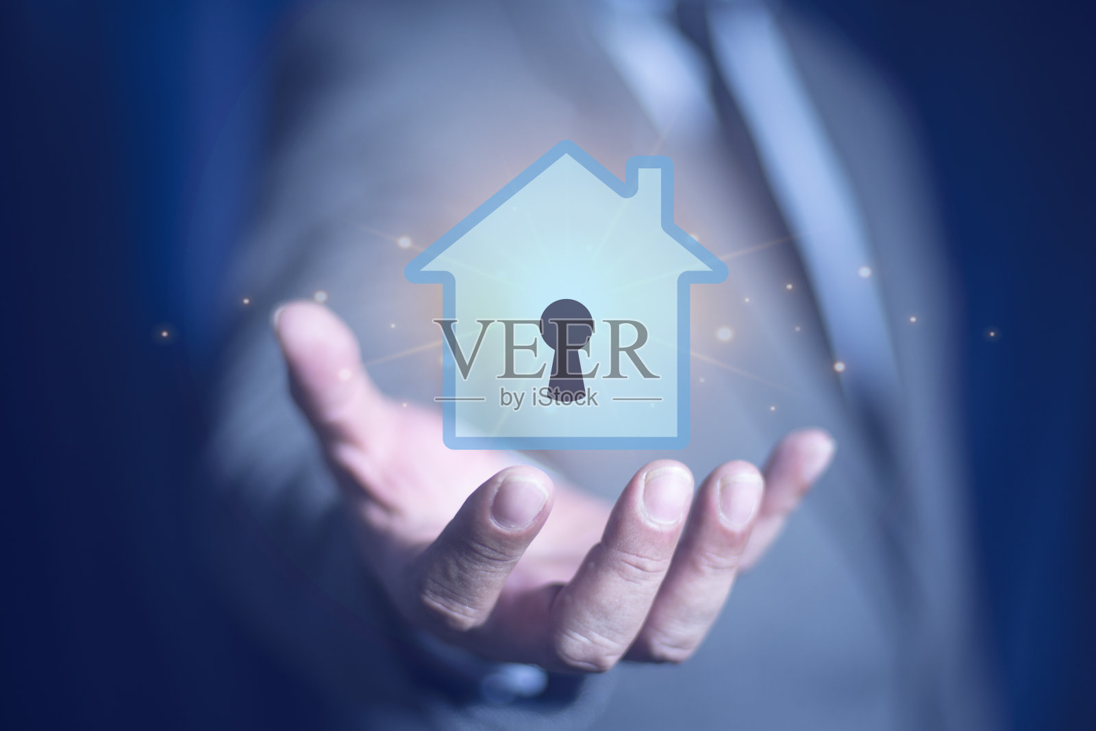 商人持有房屋图标与钥匙孔，房地产的概念照片摄影图片