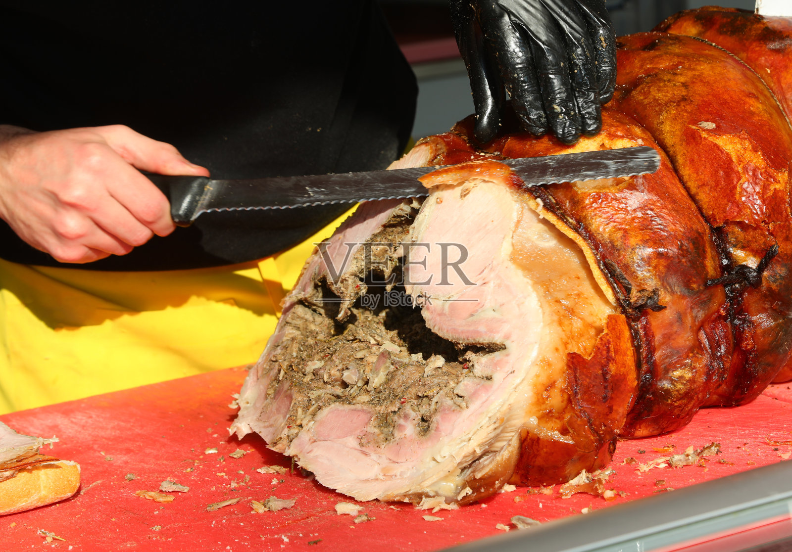 一个戴着黑色手套的屠夫的手正在切肉片——一种美味的猪肉酱照片摄影图片