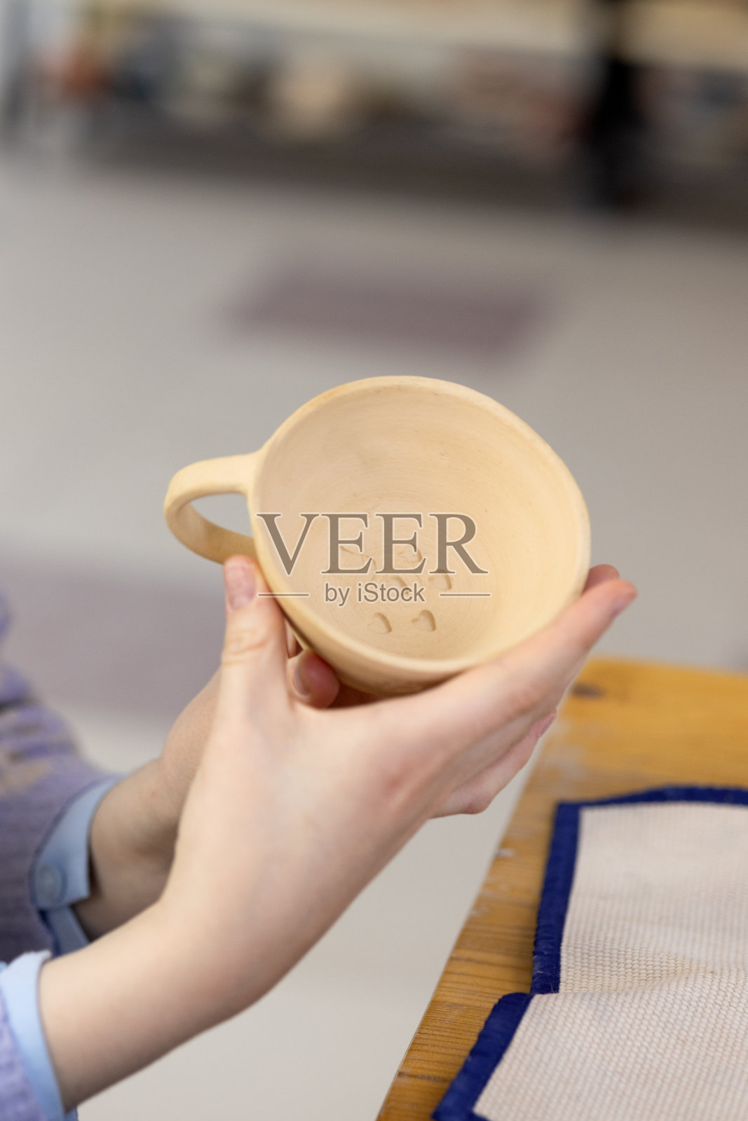 造型课开始前，老师给学生展示杯子底部的图案照片摄影图片