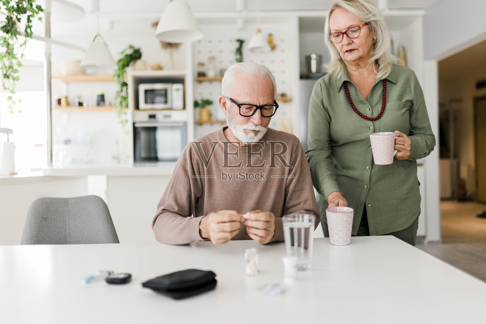 老人坐在家里从瓶子里拿药照片摄影图片