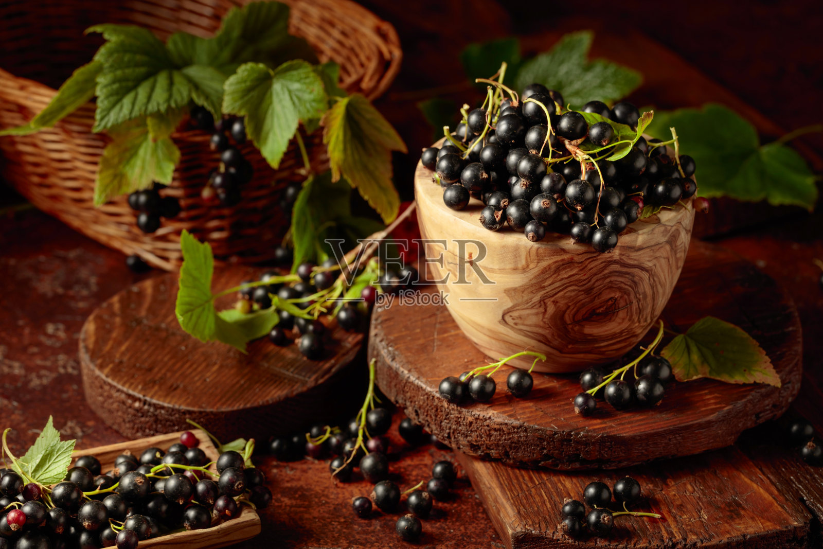 成熟的黑加仑子放在棕色的桌子上。照片摄影图片