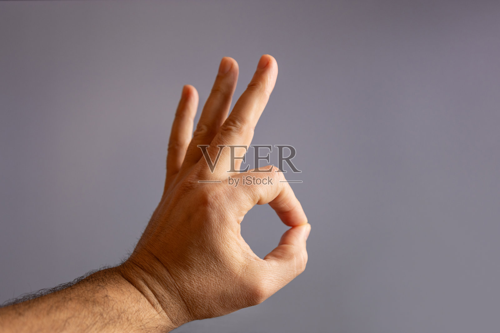 人类的手显示一个手势，一切都是好的灰色背景。照片摄影图片