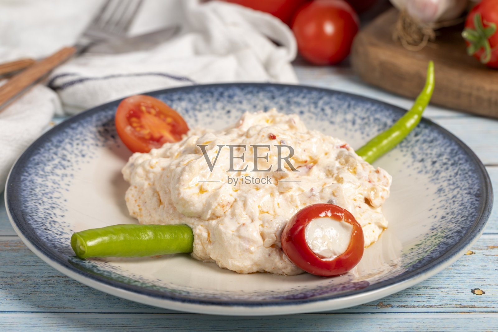 橄榄油和辛辣的开胃菜。开胃菜。原子菜辣酸奶在蓝色木制背景。本地名称atom mezesi。近距离照片摄影图片