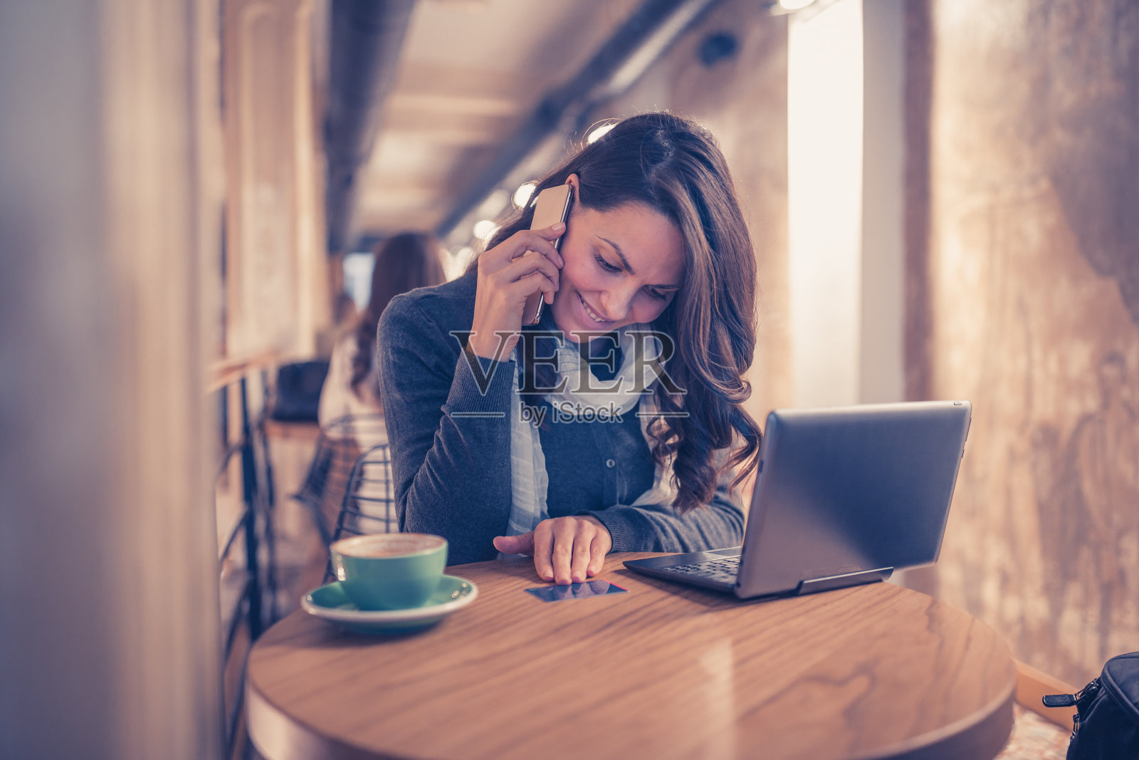 工作日早晨:女人拿着笔记本电脑打电话照片摄影图片