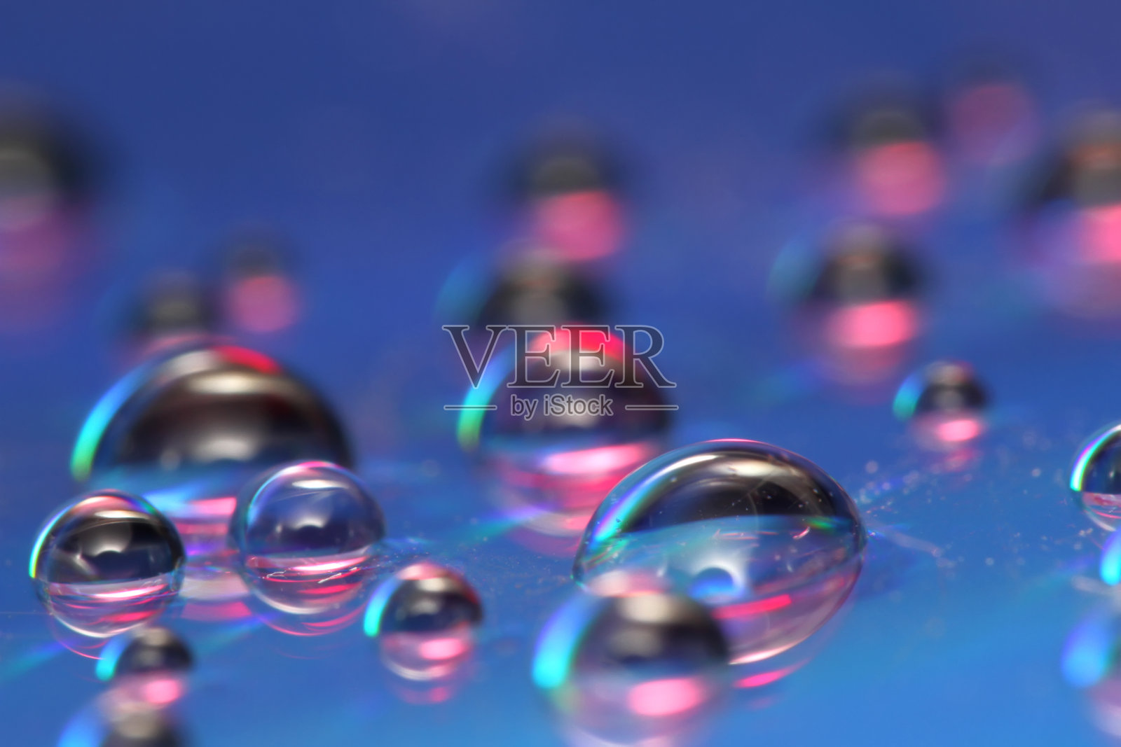 彩色抽象背景上的水滴在反射表面照片摄影图片