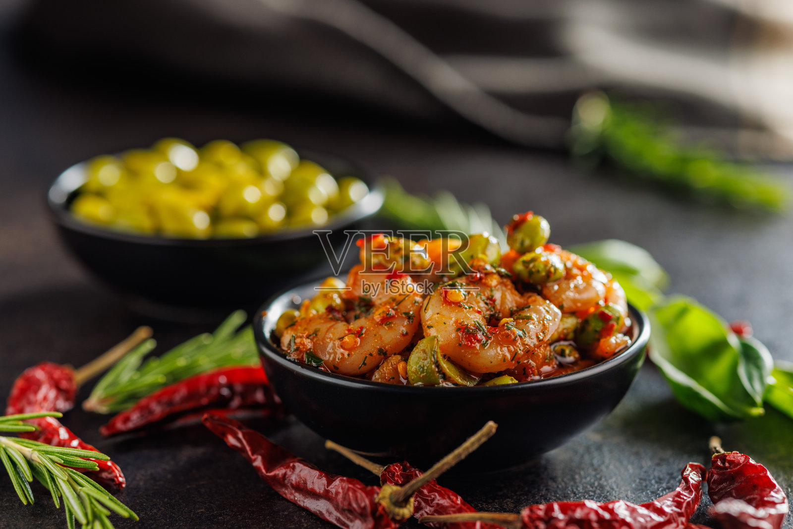 新鲜沙拉，虾和毛豆大豆在碗里，黑色的桌子。照片摄影图片