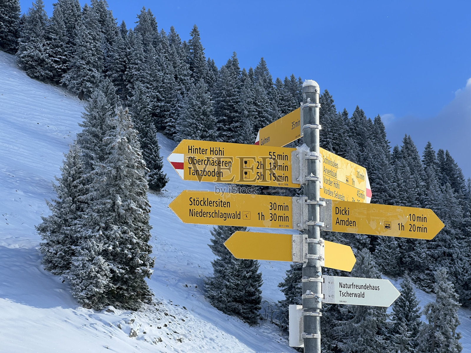 徒步旅行的标志和方向标志，以及在瓦伦湖或瓦伦施塔特湖(瓦伦湖)和瑞士阿尔卑斯山的田园诗般的冬季环境中导航的路标。照片摄影图片