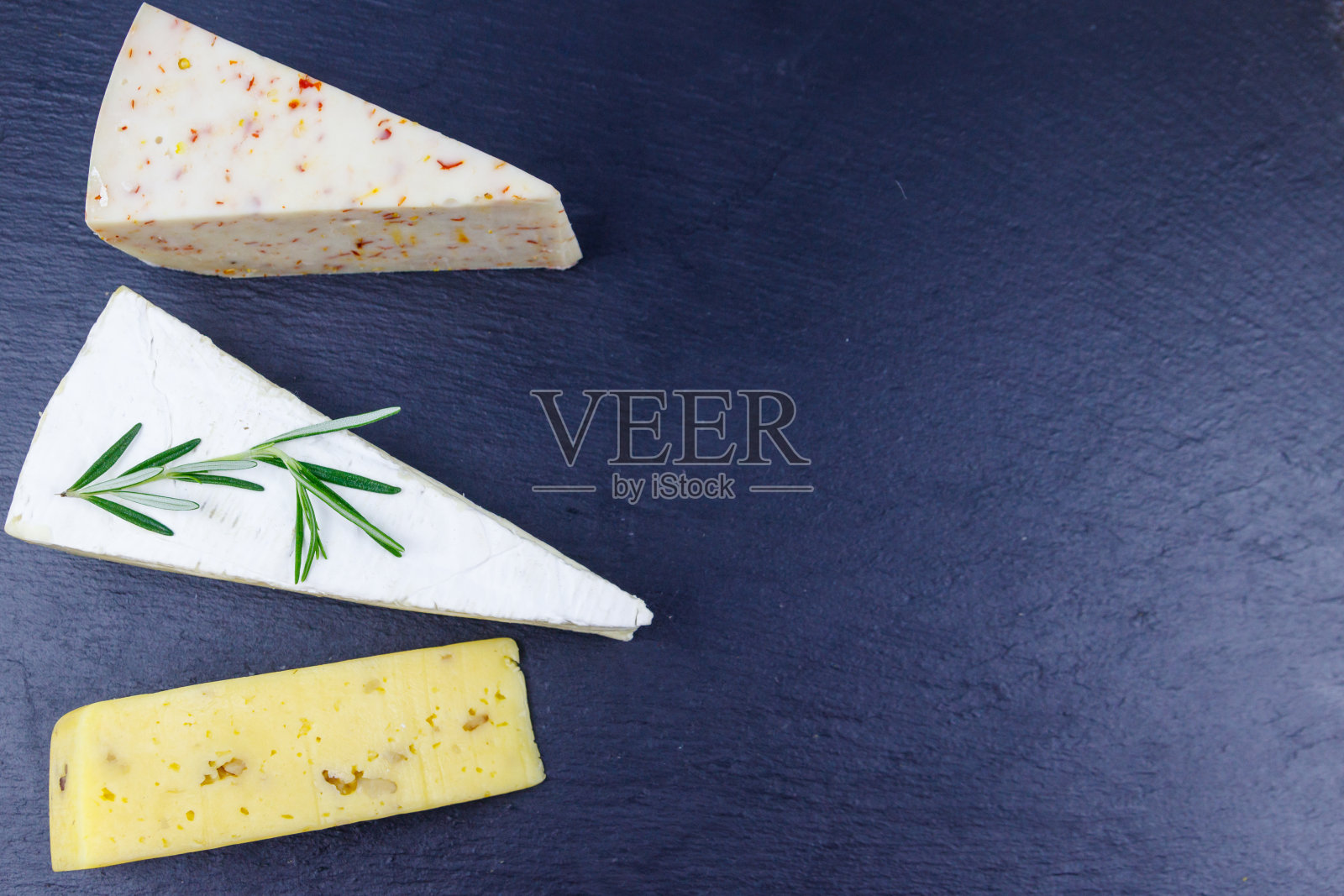 集各种类型的奶酪在黑色石板背景。俯视图照片摄影图片