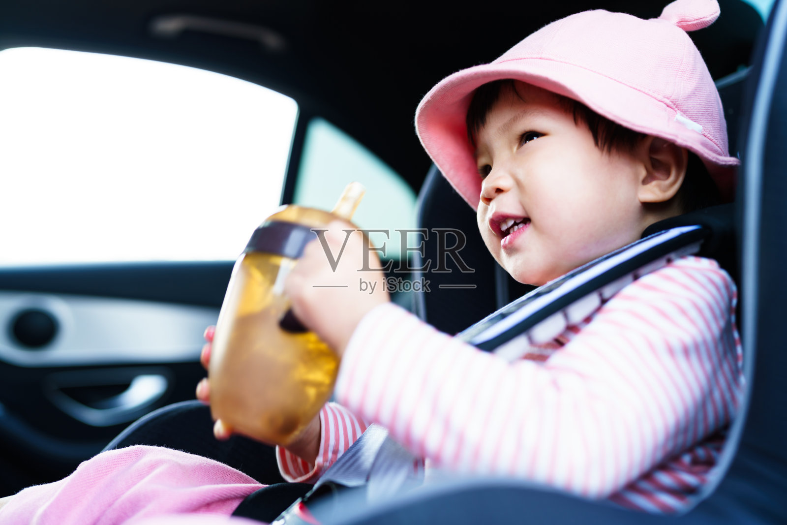 亚洲一岁大的孩子坐在车里的安全座椅上照片摄影图片