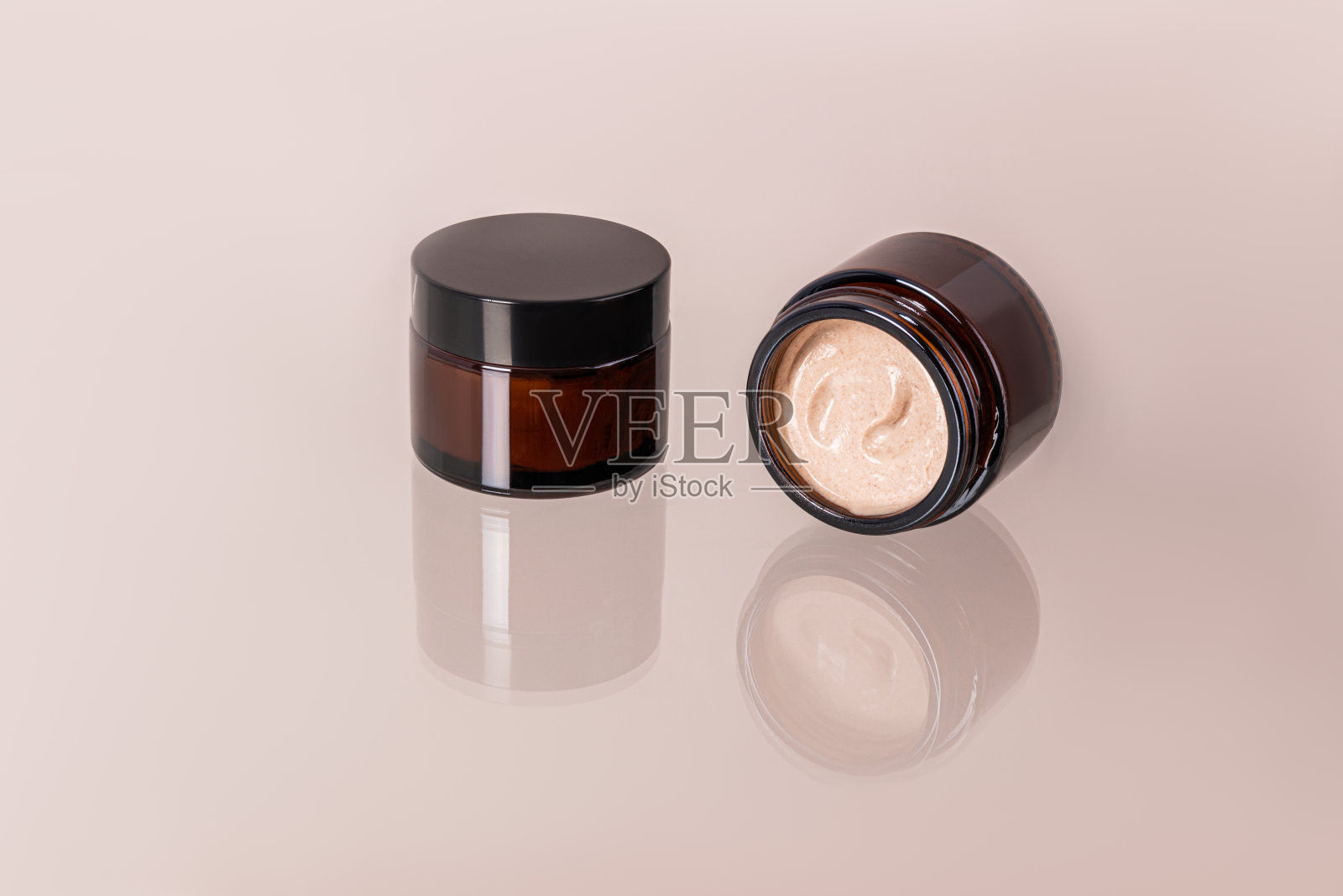 封闭和开放的罐子，用于面部和身体皮肤护理，玻璃表面有罐子的反射。米色奶油的细腻质感。照片摄影图片