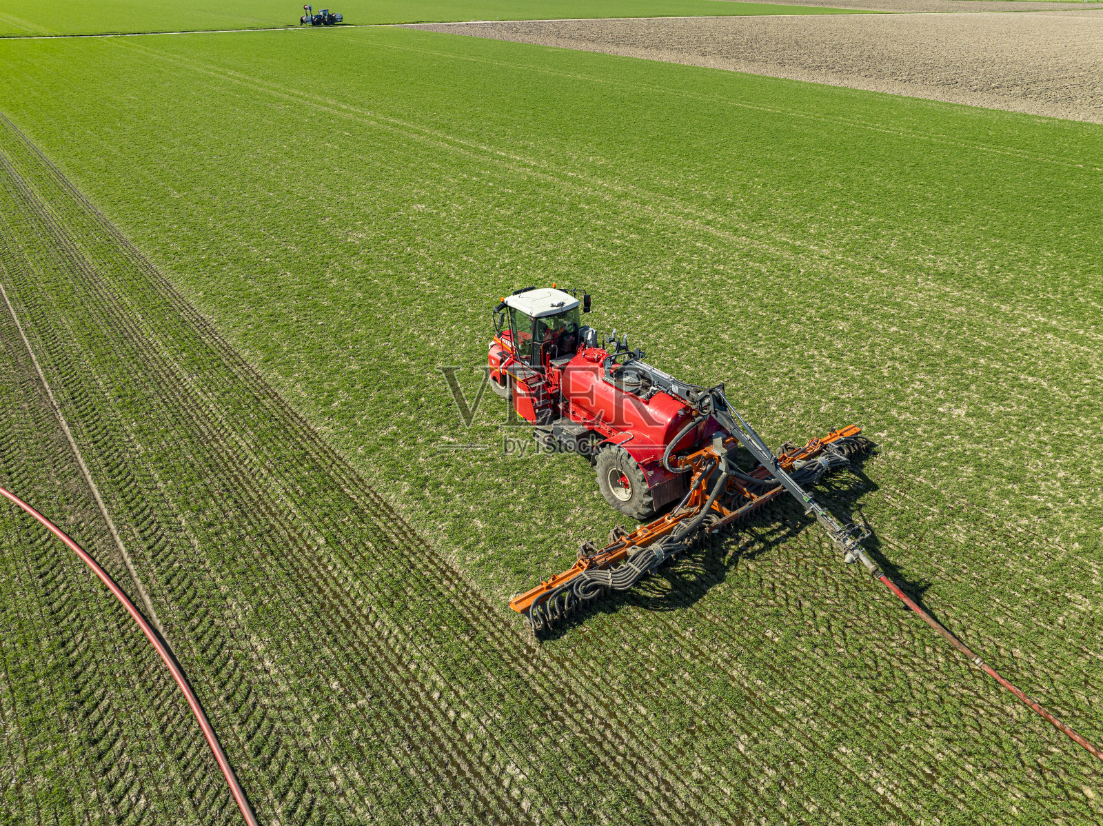 从上面看，拖拉机在田地里给牲畜注射液体肥料照片摄影图片