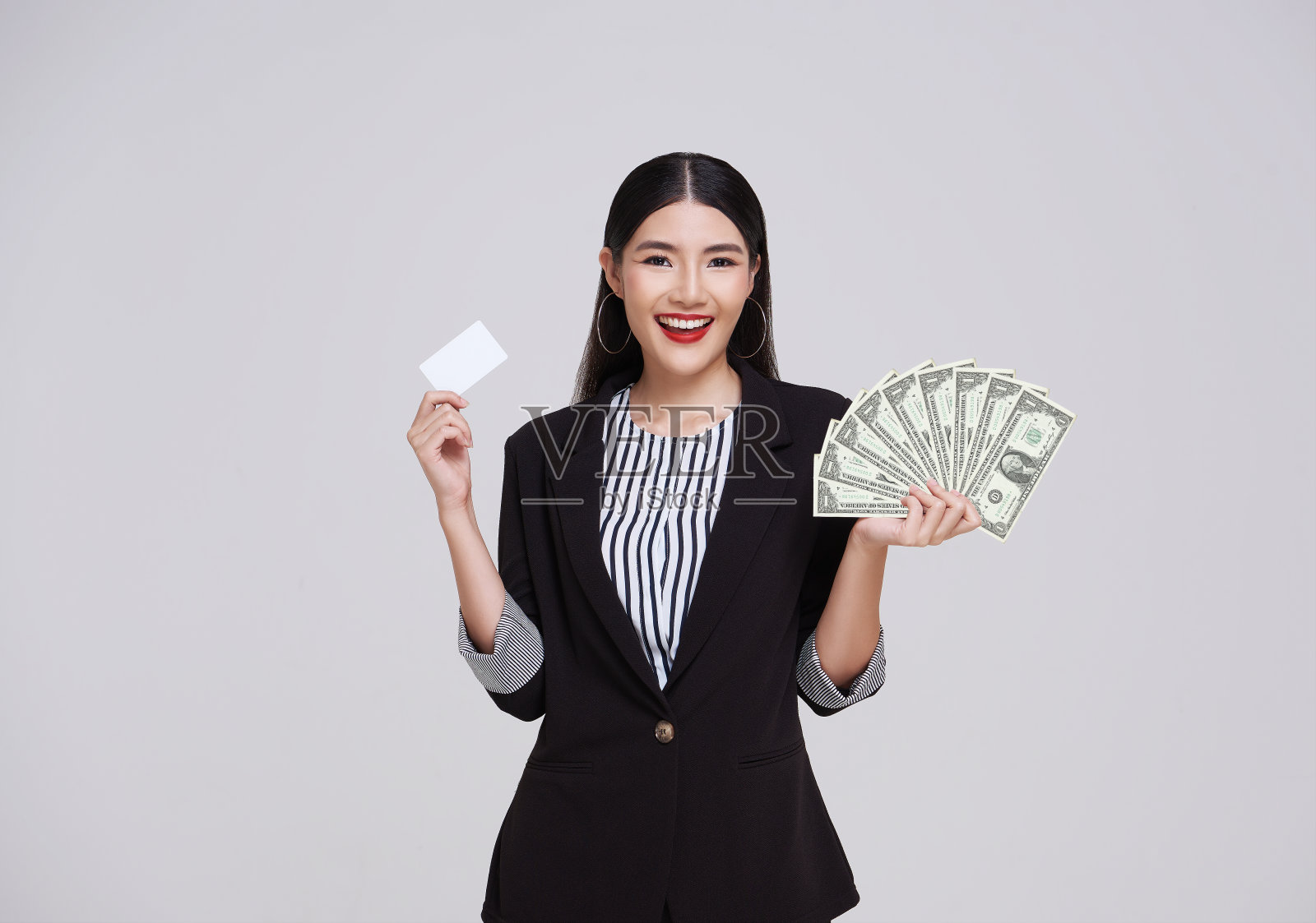 快乐的亚洲女商人展示，出示信用卡和美元，微笑和大笑，孤立在白色的工作室背景。照片摄影图片