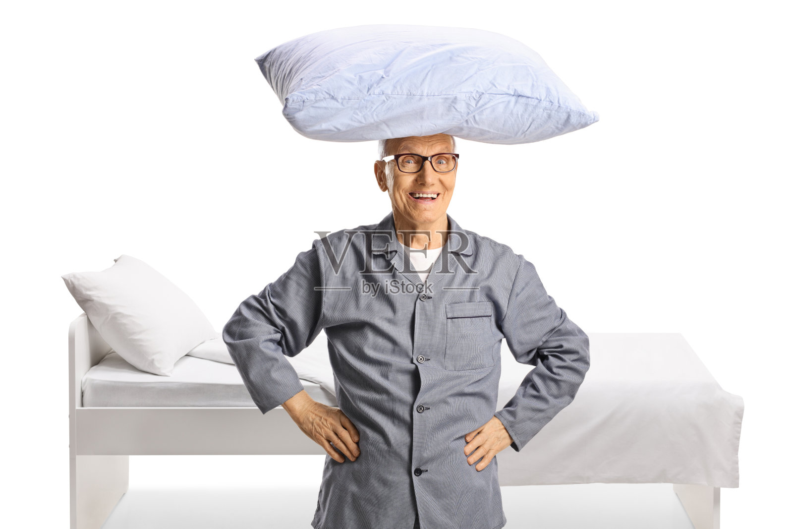 穿着睡衣，头上顶着枕头的老人站在床边照片摄影图片