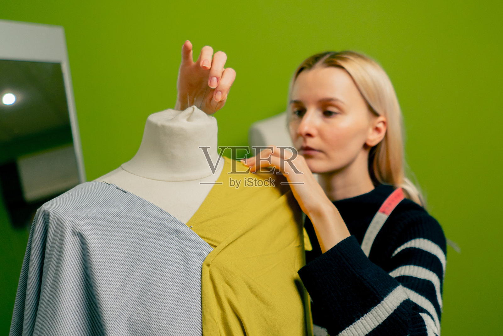 在缝纫车间的两个透明的罐子与蜡笔在织物上工作照片摄影图片