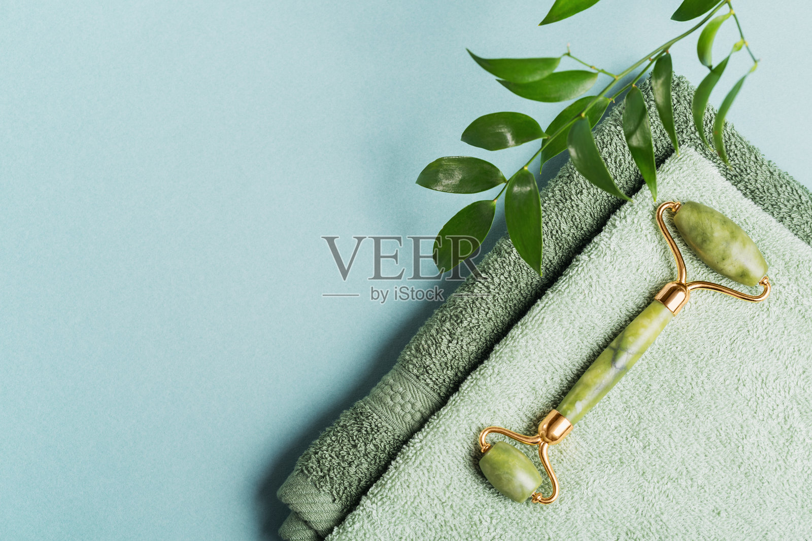 青玉面辊和绿叶在浅蓝色的背景照片摄影图片