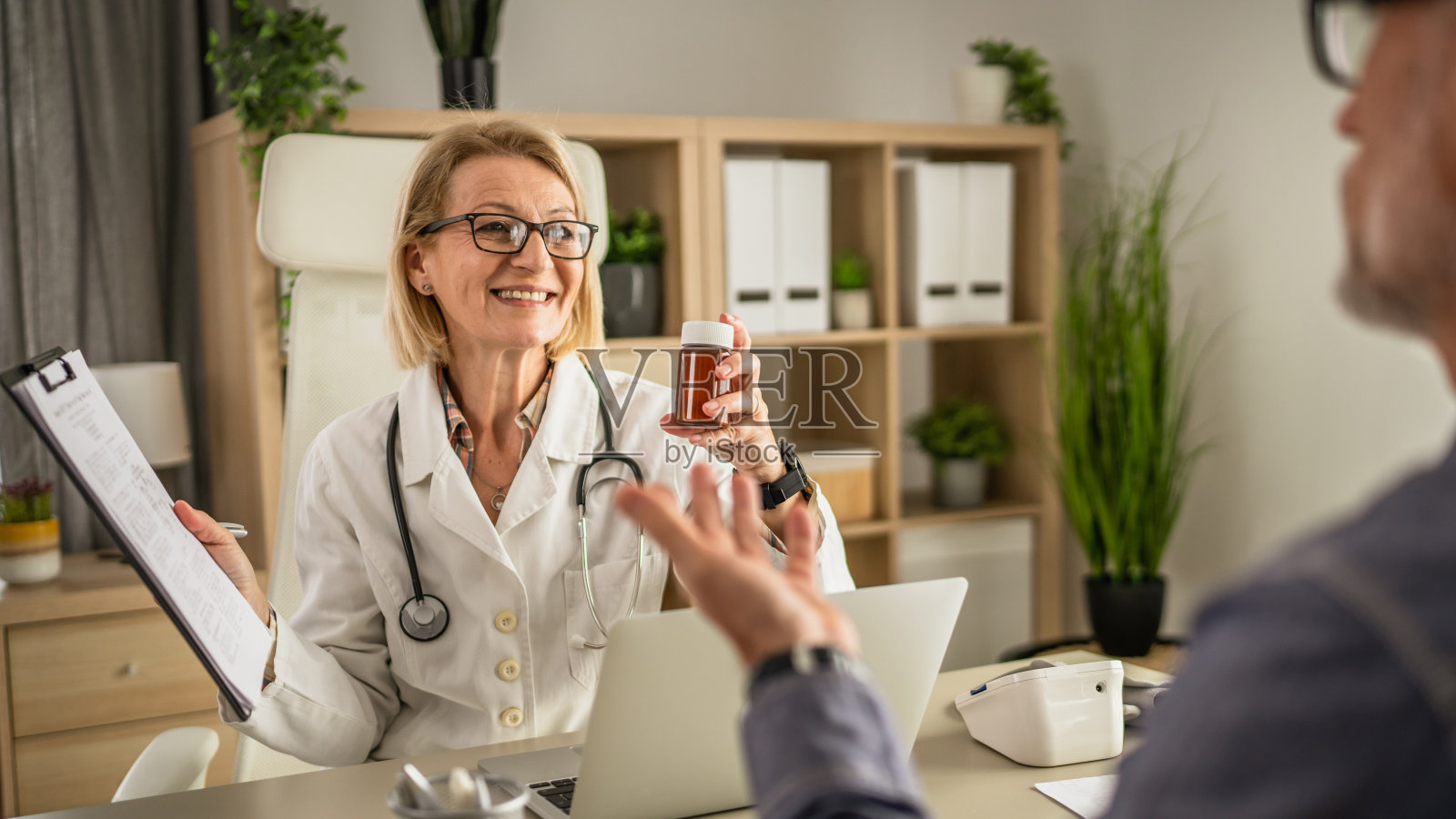 女医生拿着药物和医疗文件给病人看照片摄影图片