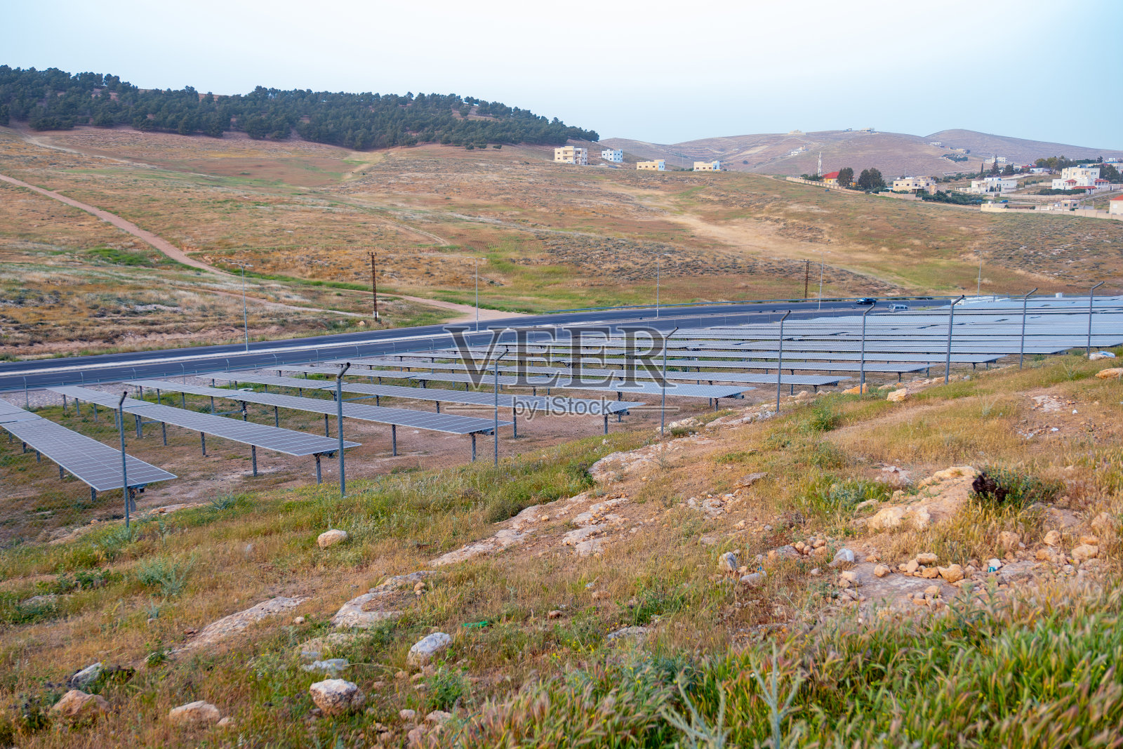 户外绿色土地上使用光伏板发电，旁边有街道照片摄影图片