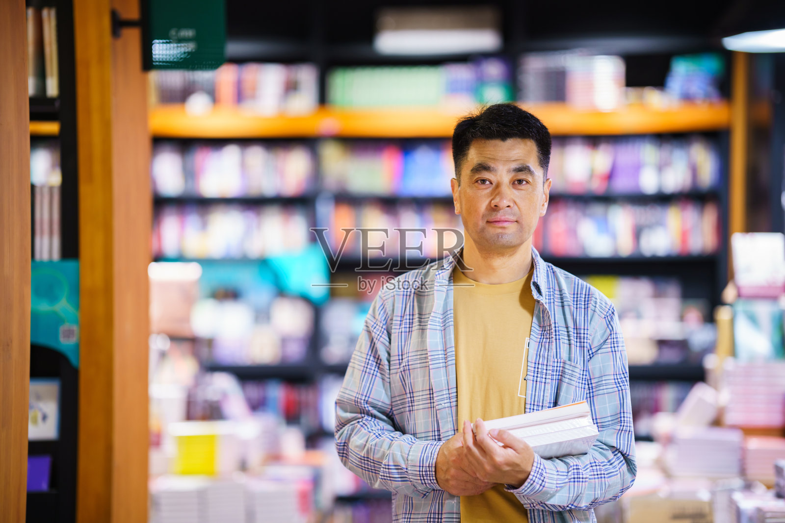 亚洲中年男子在市公共图书馆借书照片摄影图片