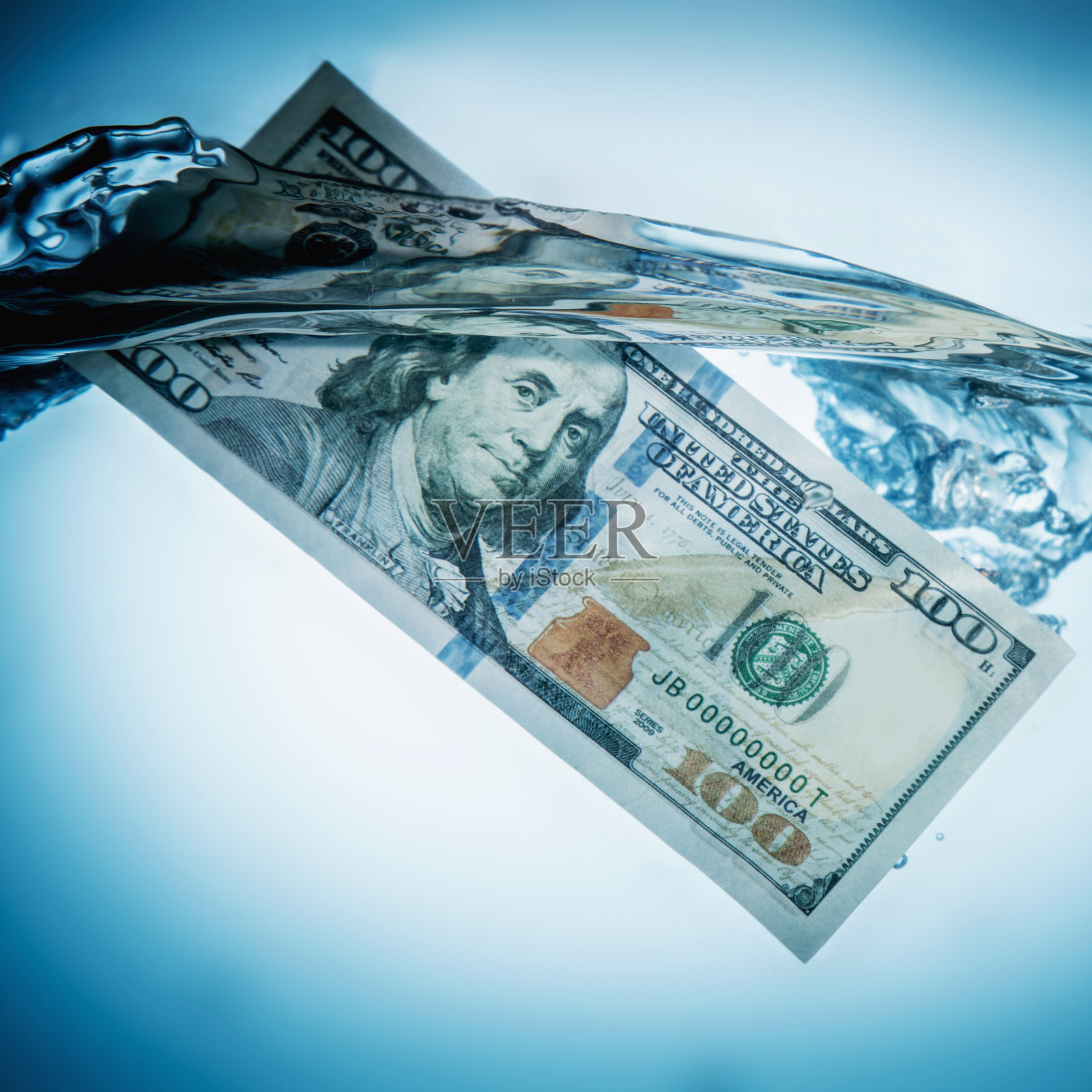 全球经济和金融危机。特写:美元沉入水中，象征着不确定的国际贸易和投资前景。照片摄影图片