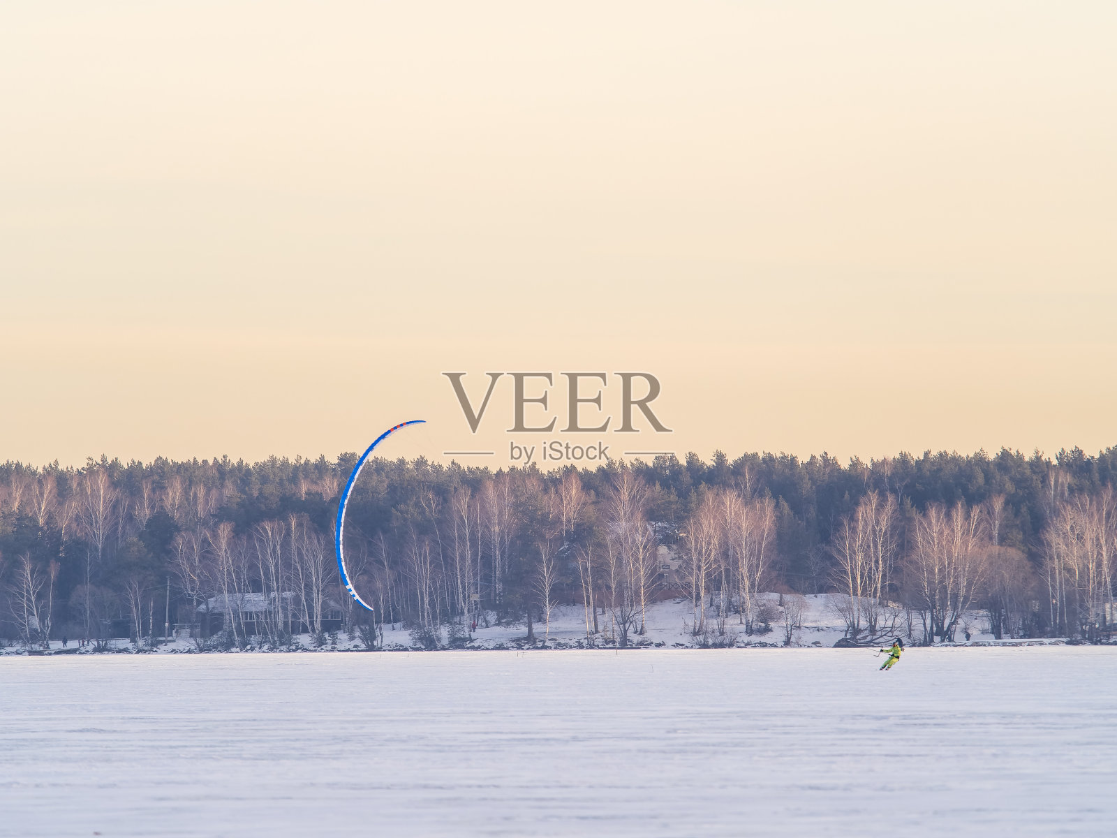 风筝冲浪者骑在滑雪板上。在冰湖上的雪地里打雪仗。照片摄影图片