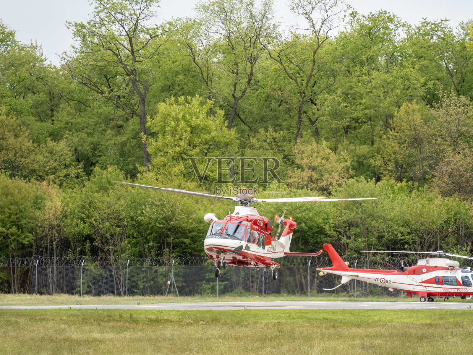 消防直升机正在马尔彭萨机场总部降落。一架红白相间的直升机照片摄影图片