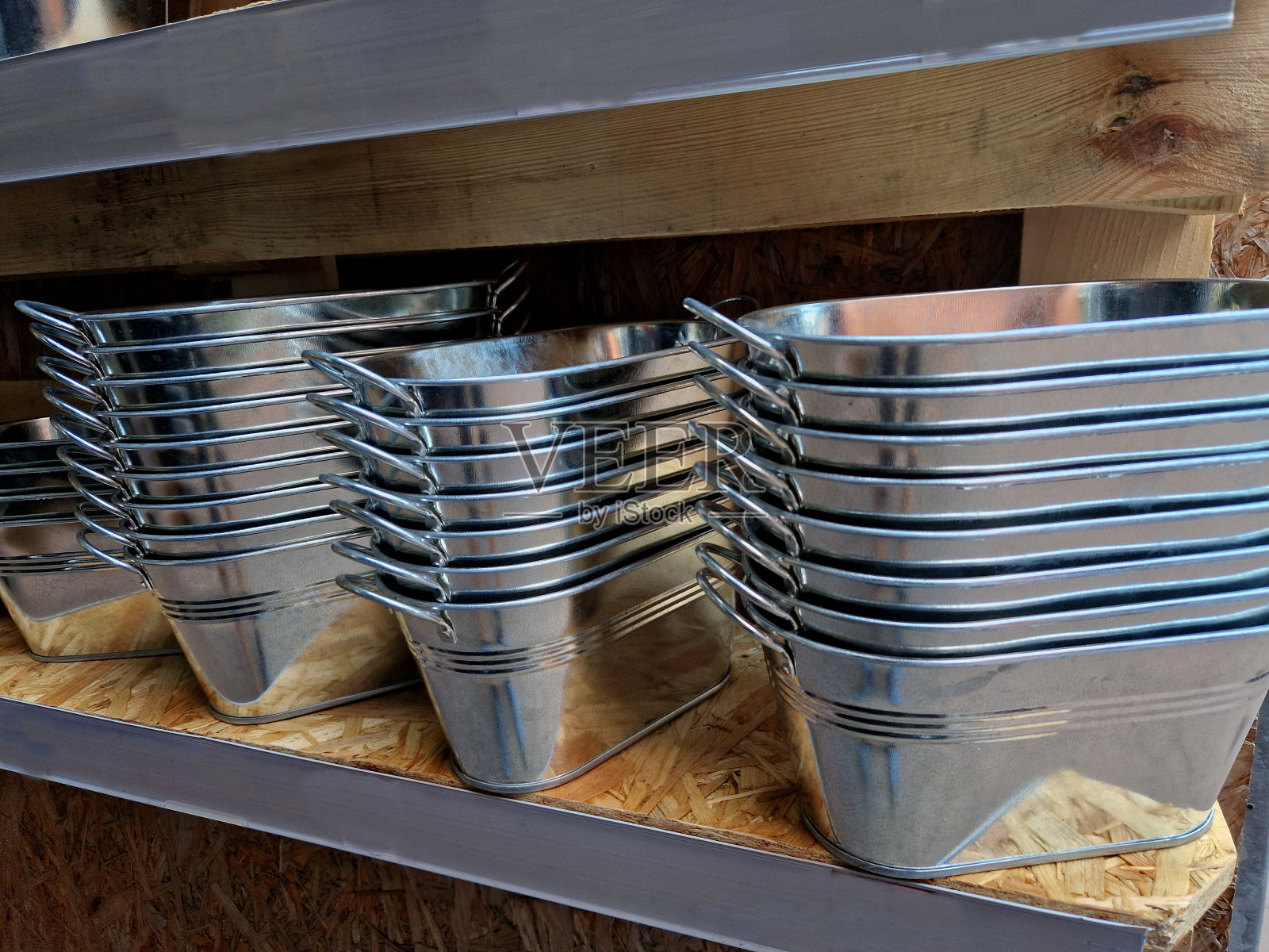 锡制花盆是外面露台上的装饰品。这些花被种植并放置在一个桶或盆里，一个由镀锌金属板制成的碗里照片摄影图片