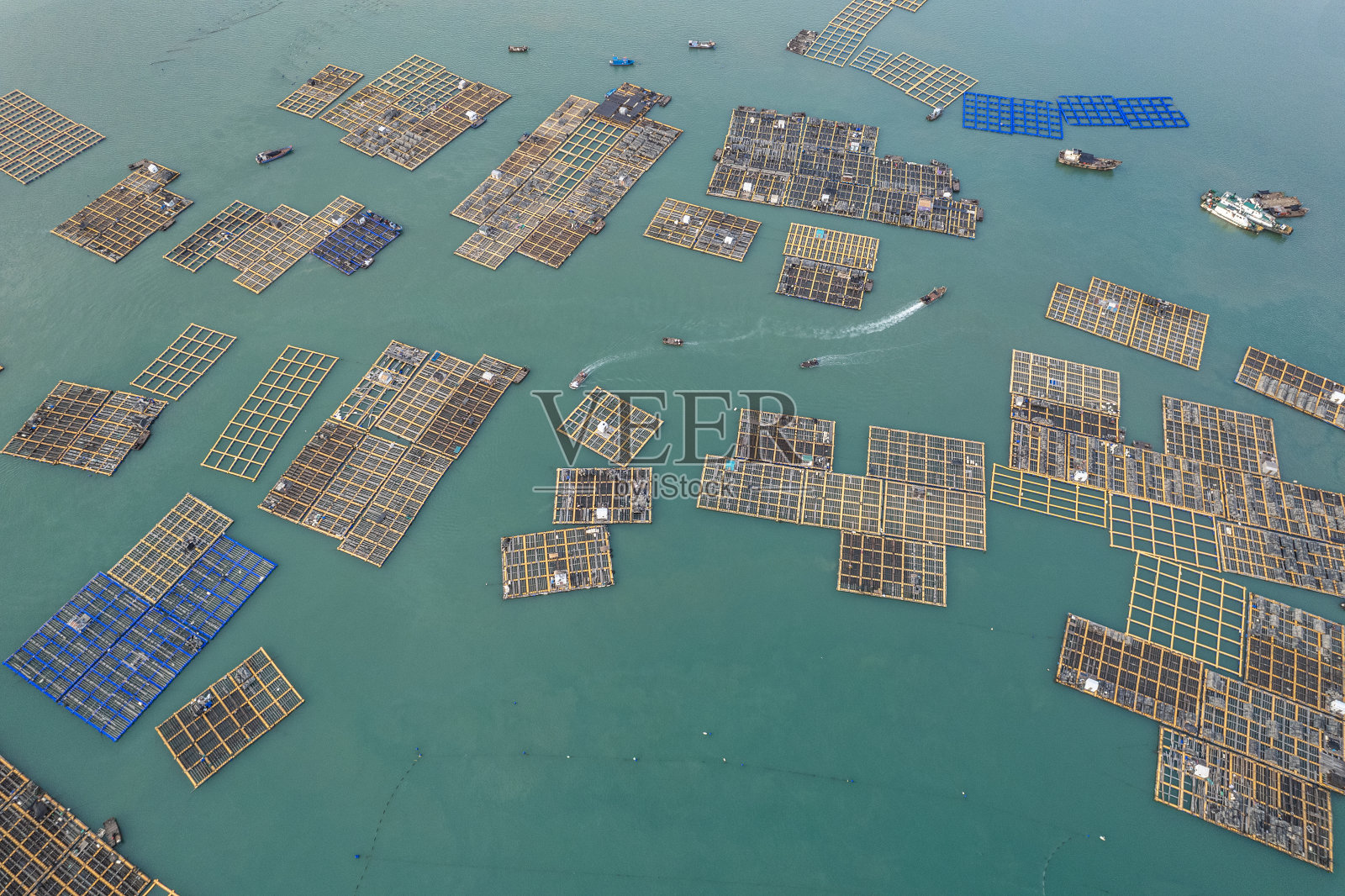 垂直鸟瞰捕鱼和水产养殖场，一艘船在海上航行照片摄影图片