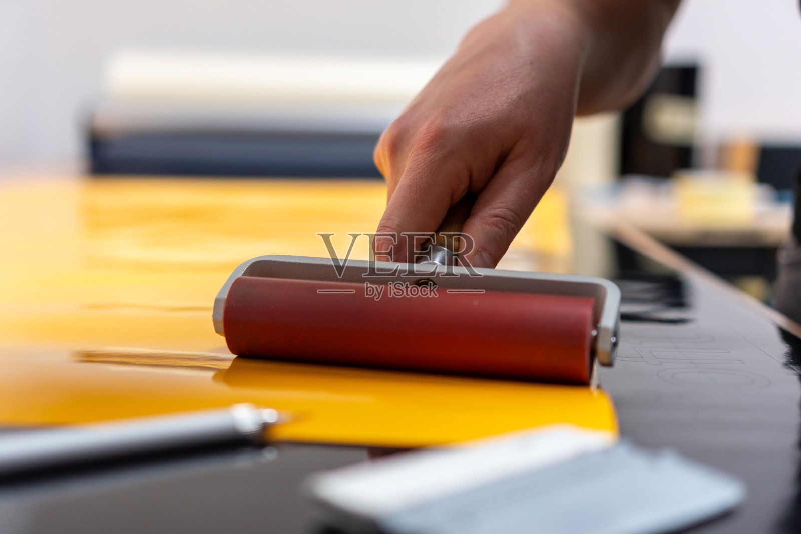 在制作广告贴纸时，一只手拿着滚轮照片摄影图片