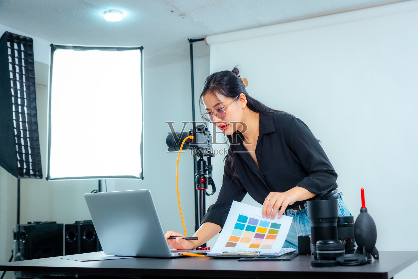 女摄影师开会挑选照片和检查颜色的工作室照片摄影图片