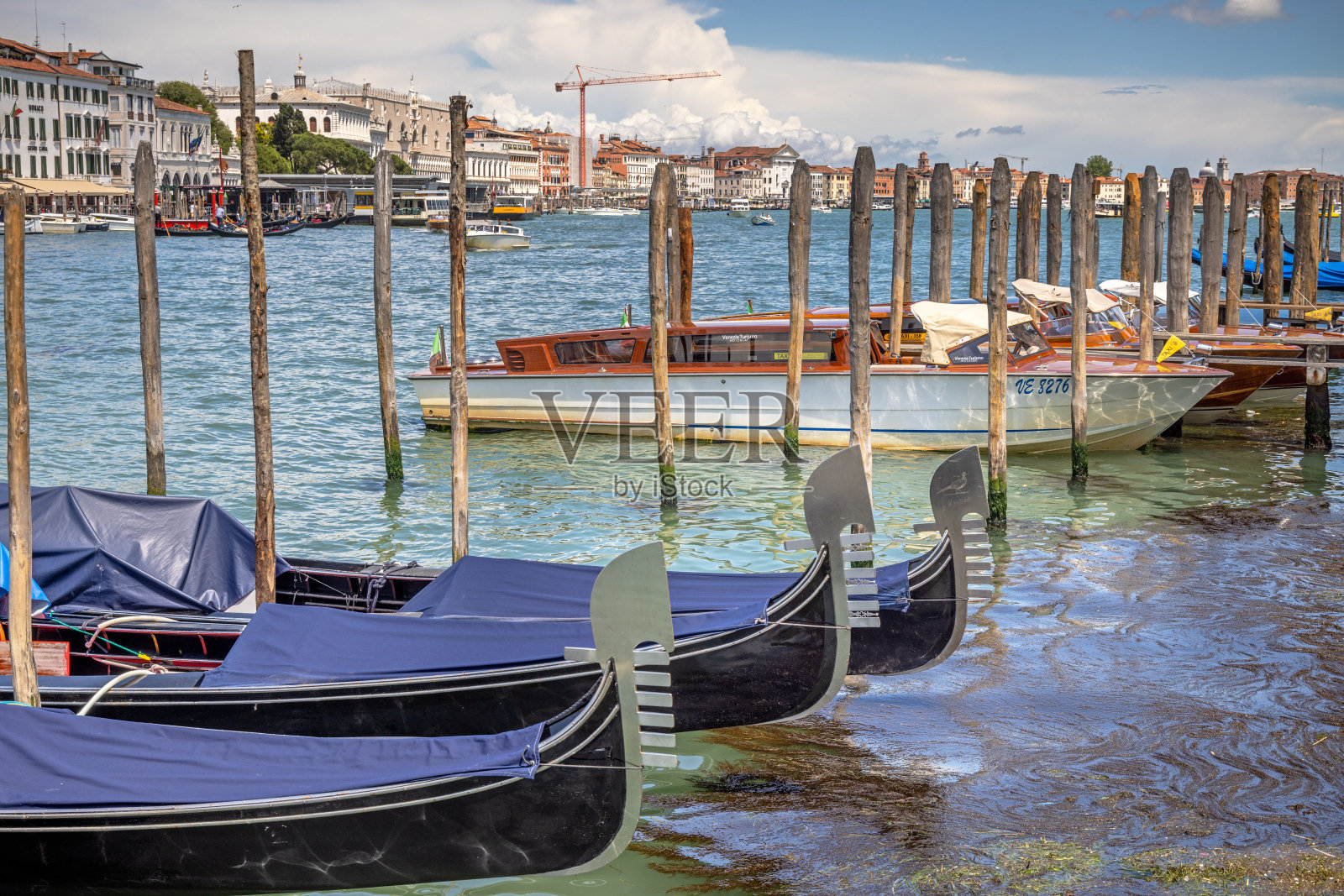 在防水油布下停泊的贡多拉和一辆水上出租车照片摄影图片