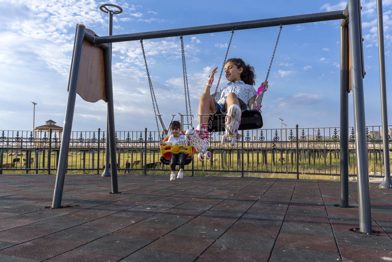 两个兄弟在荡秋千。照片摄影图片