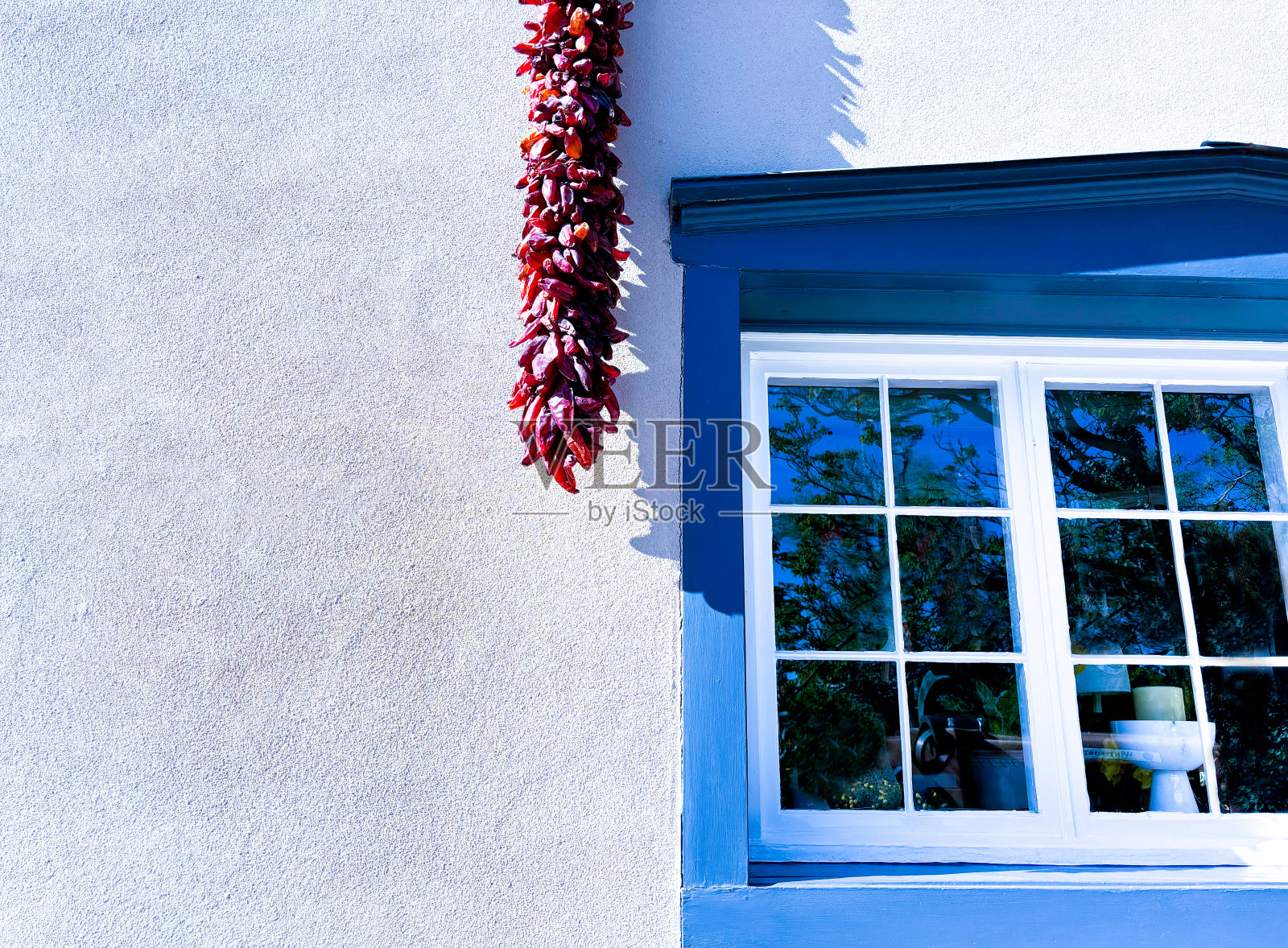 圣达菲，新墨西哥州:红色瑞斯特拉挂在蓝色窗户附近照片摄影图片