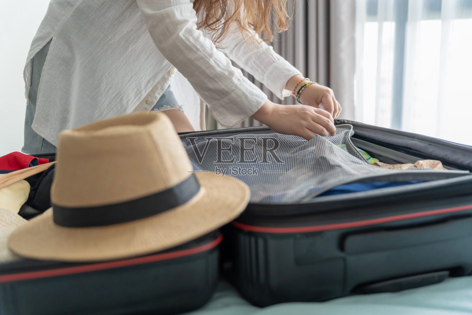 女人打包行李在床上为旅行计划准备度假的新旅程装箱单现在旅行运输照片摄影图片