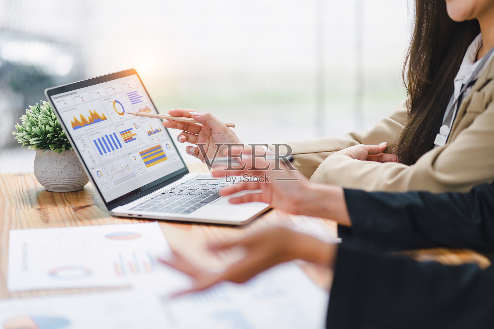 两个专业分析金融数据图表，图表在笔记本电脑上显示在一个现代化的工作空间。财务分析或业务评估概念照片摄影图片