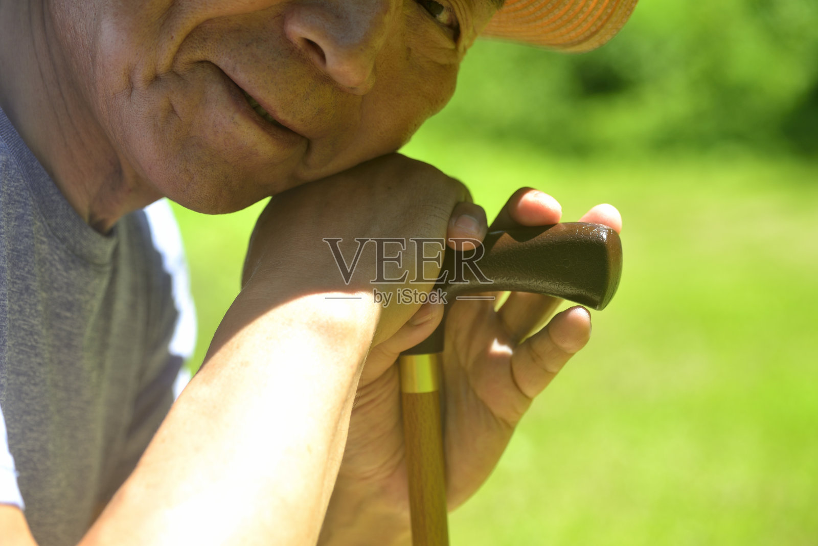 微笑的老人拄着拐杖走路照片摄影图片