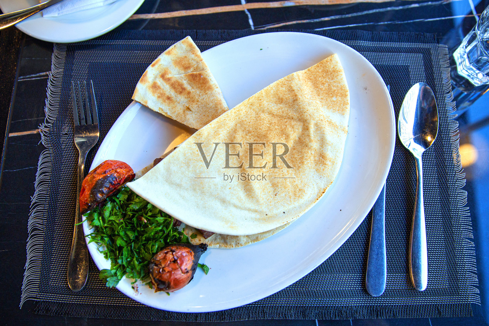 搭配皮塔饼、炖番茄和香草的传统叙利亚烤肉串照片摄影图片