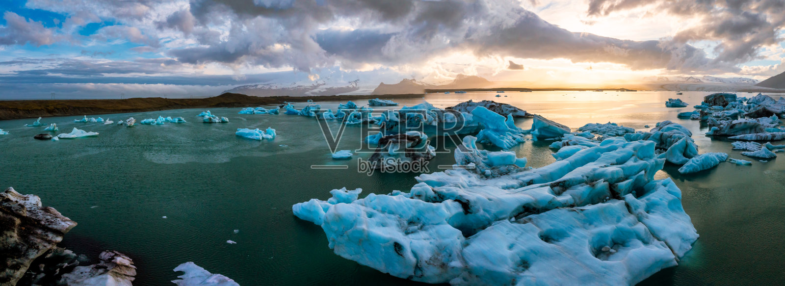 日落时分Jokulsarlon冰川泻湖令人惊叹的鸟瞰图，展示了冰岛最受欢迎的旅游目的地宁静的水域中漂浮的令人惊叹的冰山。照片摄影图片