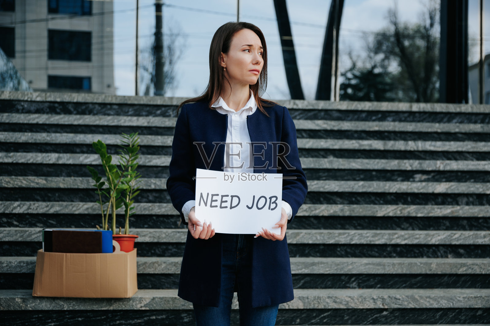 失业的悲伤：拿着需要工作banner的悲伤女人照片摄影图片