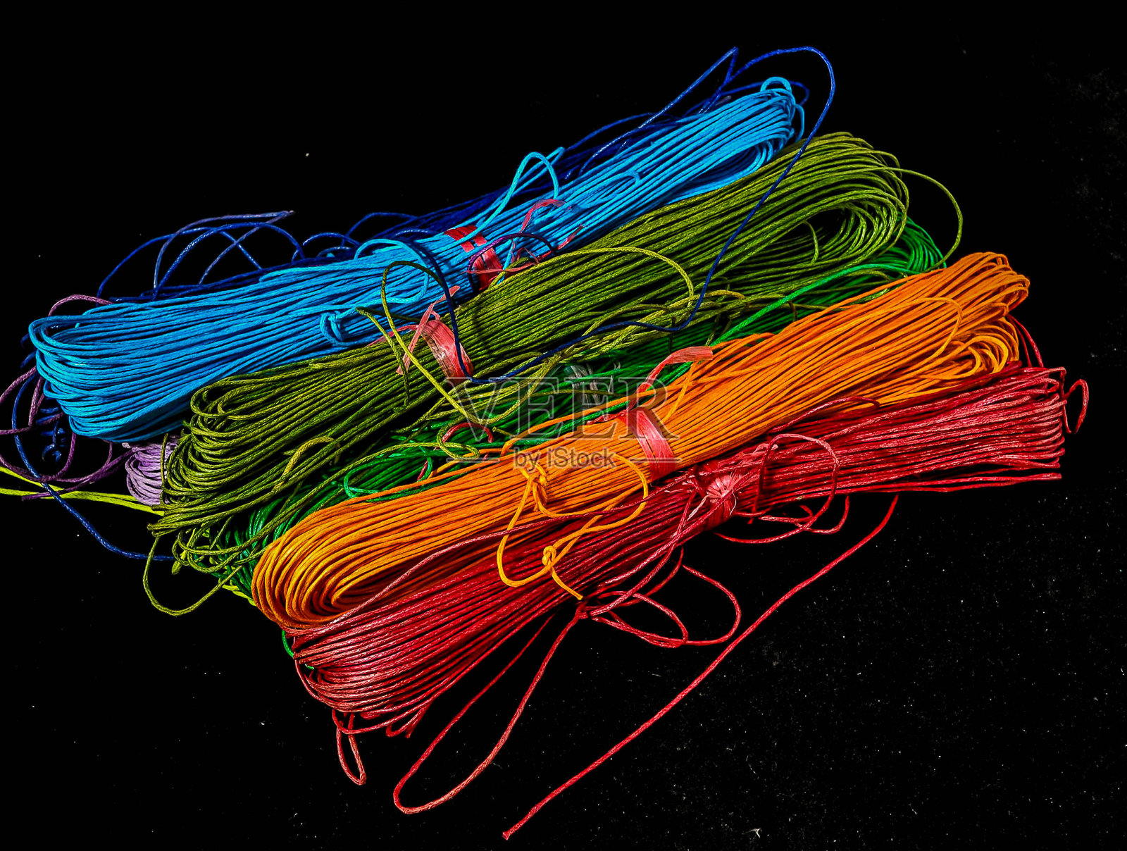 一串彩色的绳子在黑色的背景上照片摄影图片