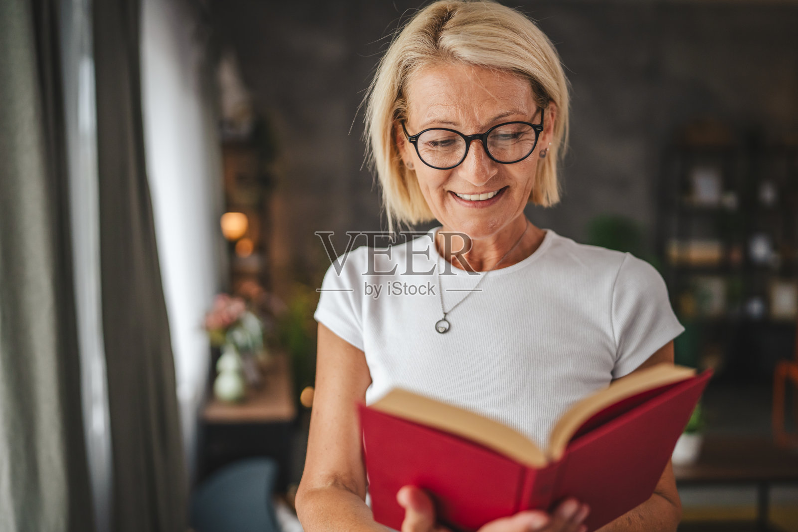 成熟的资深女性斯坦和在家里看书的肖像照片摄影图片