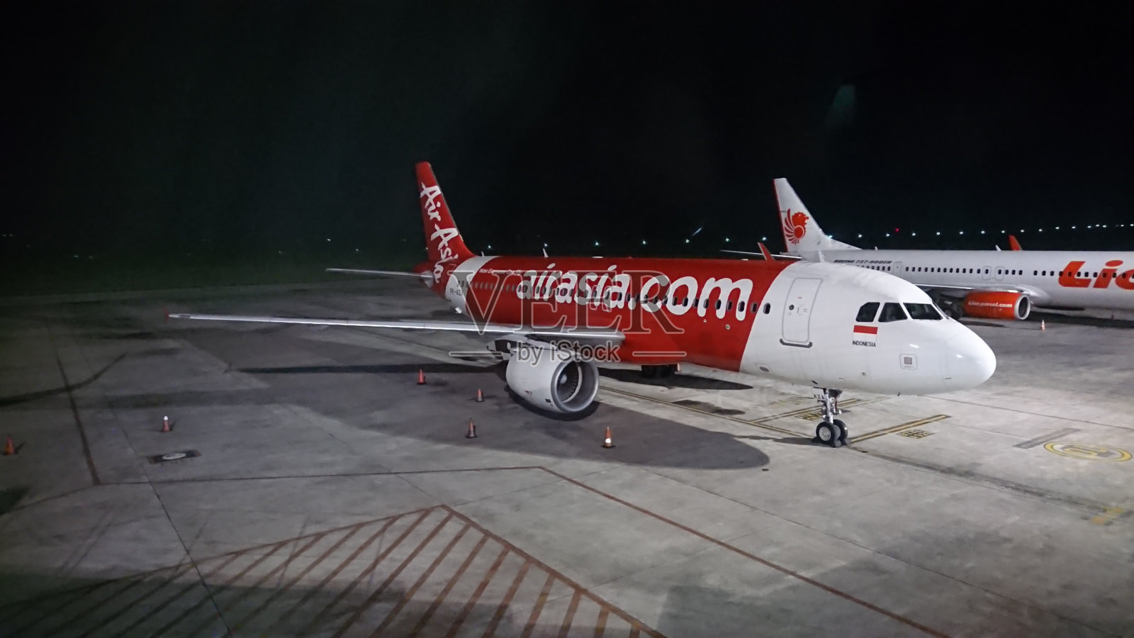 亚洲航空公司和狮子航空公司的飞机停在印度尼西亚龙目岛中部的龙目岛国际机场照片摄影图片