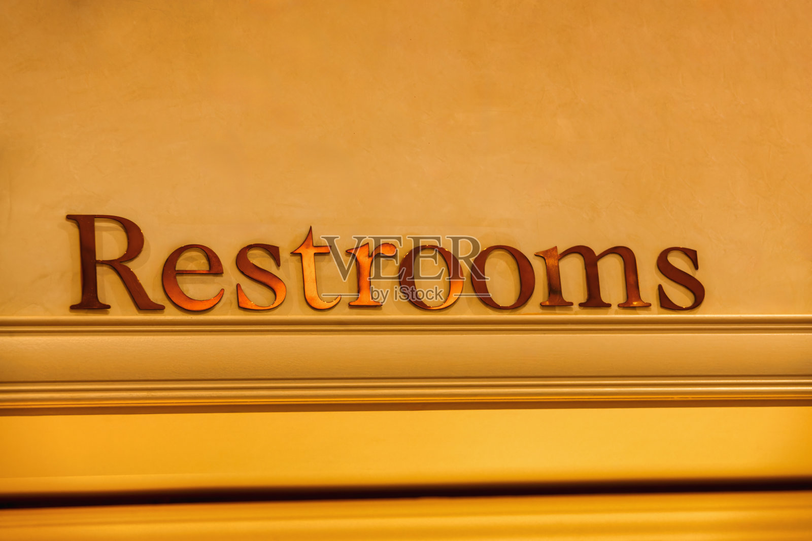 卫生间的招牌贴在墙上，字体文字用金色的字母照片摄影图片