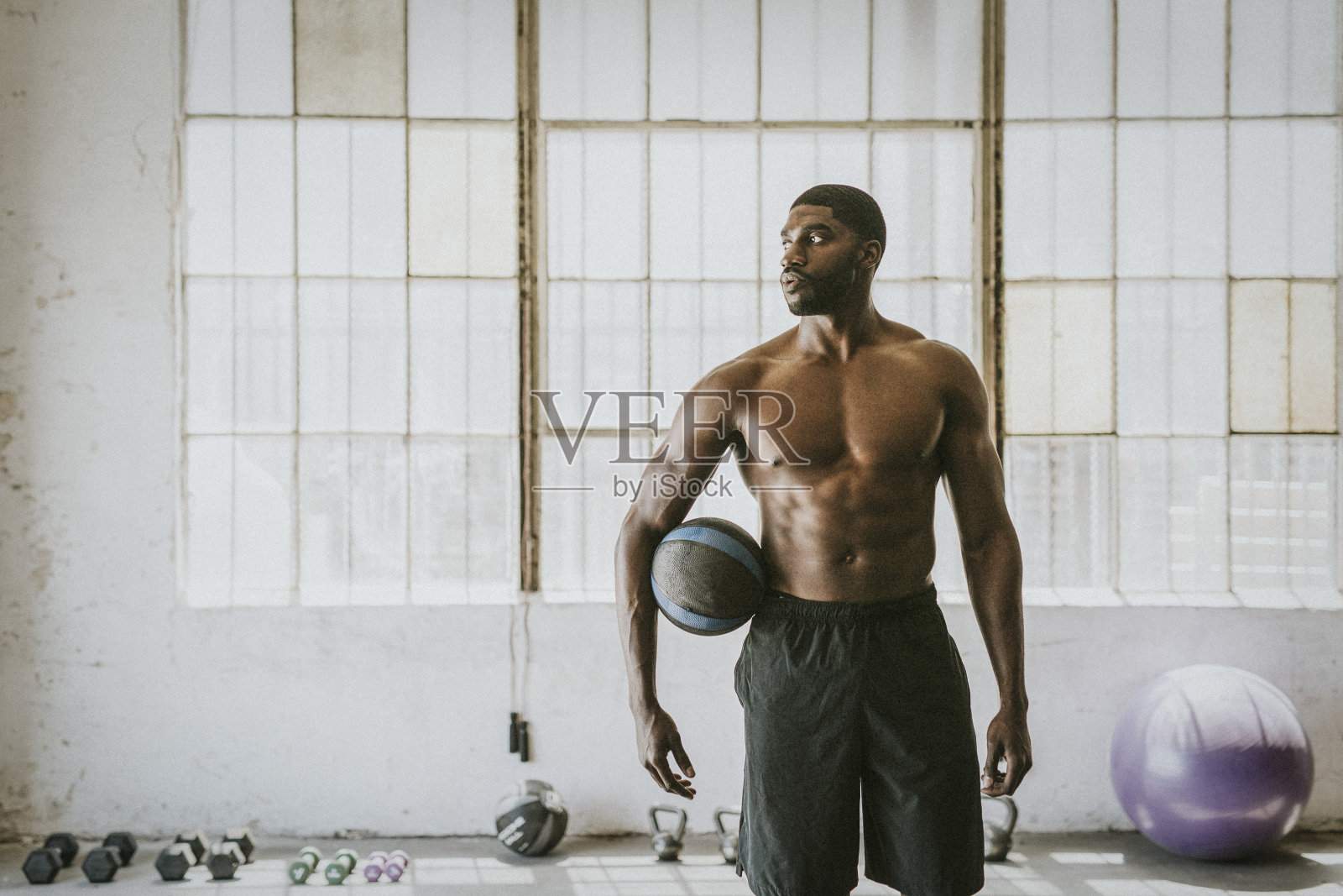 赤裸上身的肌肉的男拿着健身球照片摄影图片