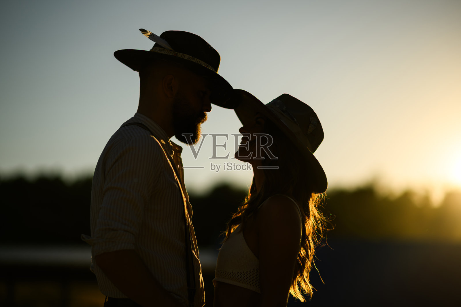 农场主夫妇站在牧场外面的侧视图和剪影。照片摄影图片