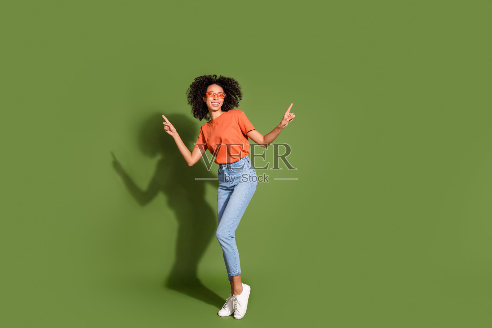 可爱的年轻女士太阳镜跳舞的全身照片穿着时尚的橙色服装孤立的卡其色背景照片摄影图片