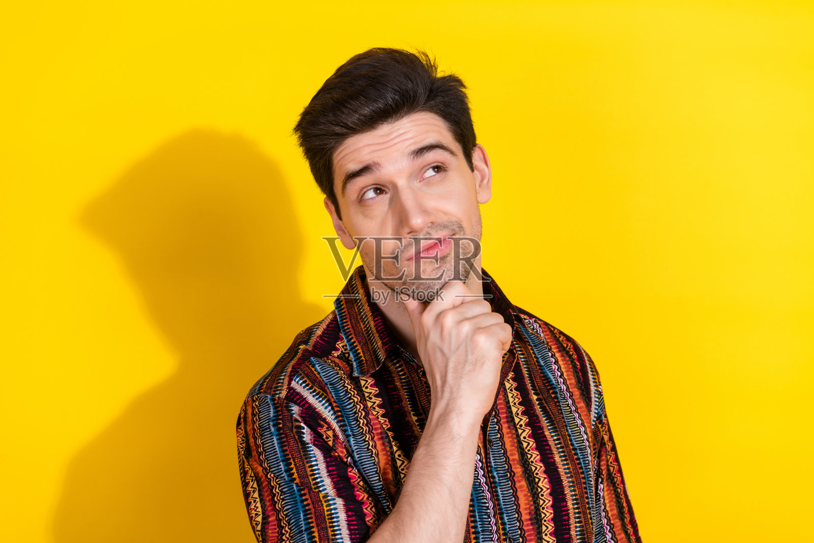 照片中漂亮的年轻人看起来空无一人，穿着黄色背景上孤立的衬衫照片摄影图片