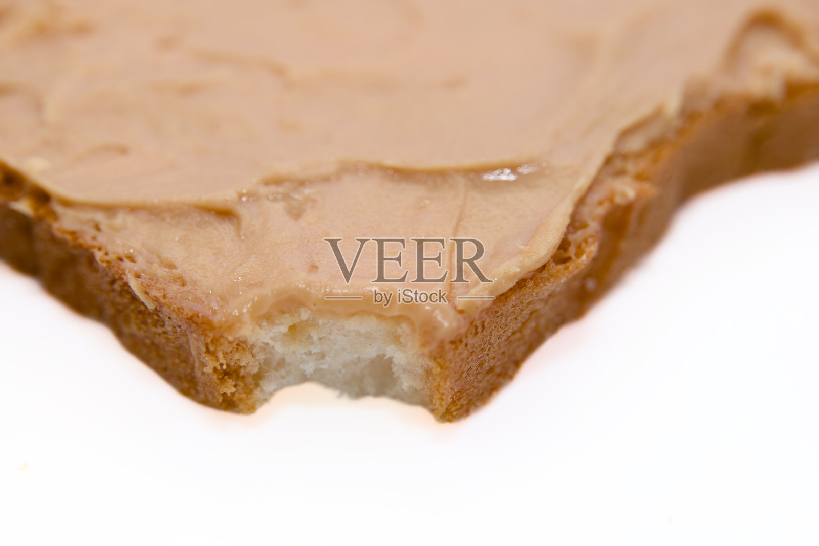 咬一口花生酱面包片照片摄影图片