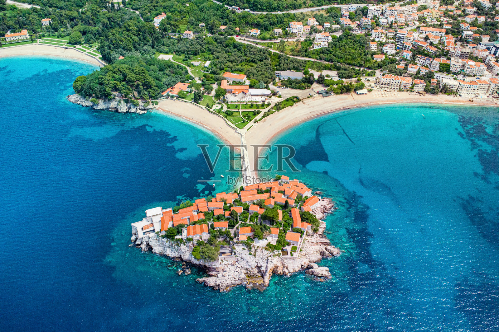 黑山的Sveti Stefan从上面俯瞰，拥有风景如画的橙色屋顶的房子，蓝色的海水和郁郁葱葱的海岸线，非常适合暑假。照片摄影图片