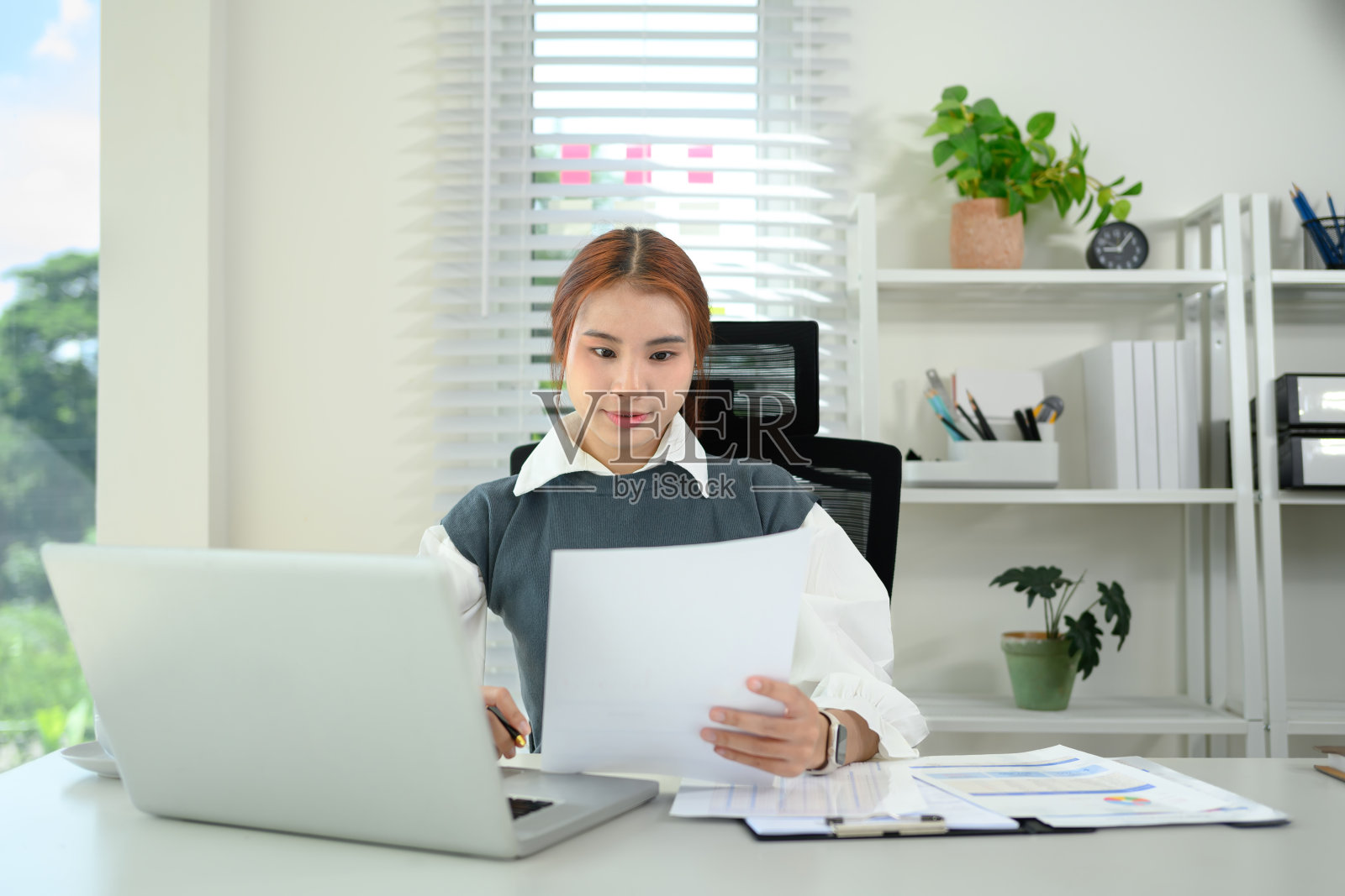 年轻企业家在办公室用笔记本电脑和财务文件工作的照片照片摄影图片